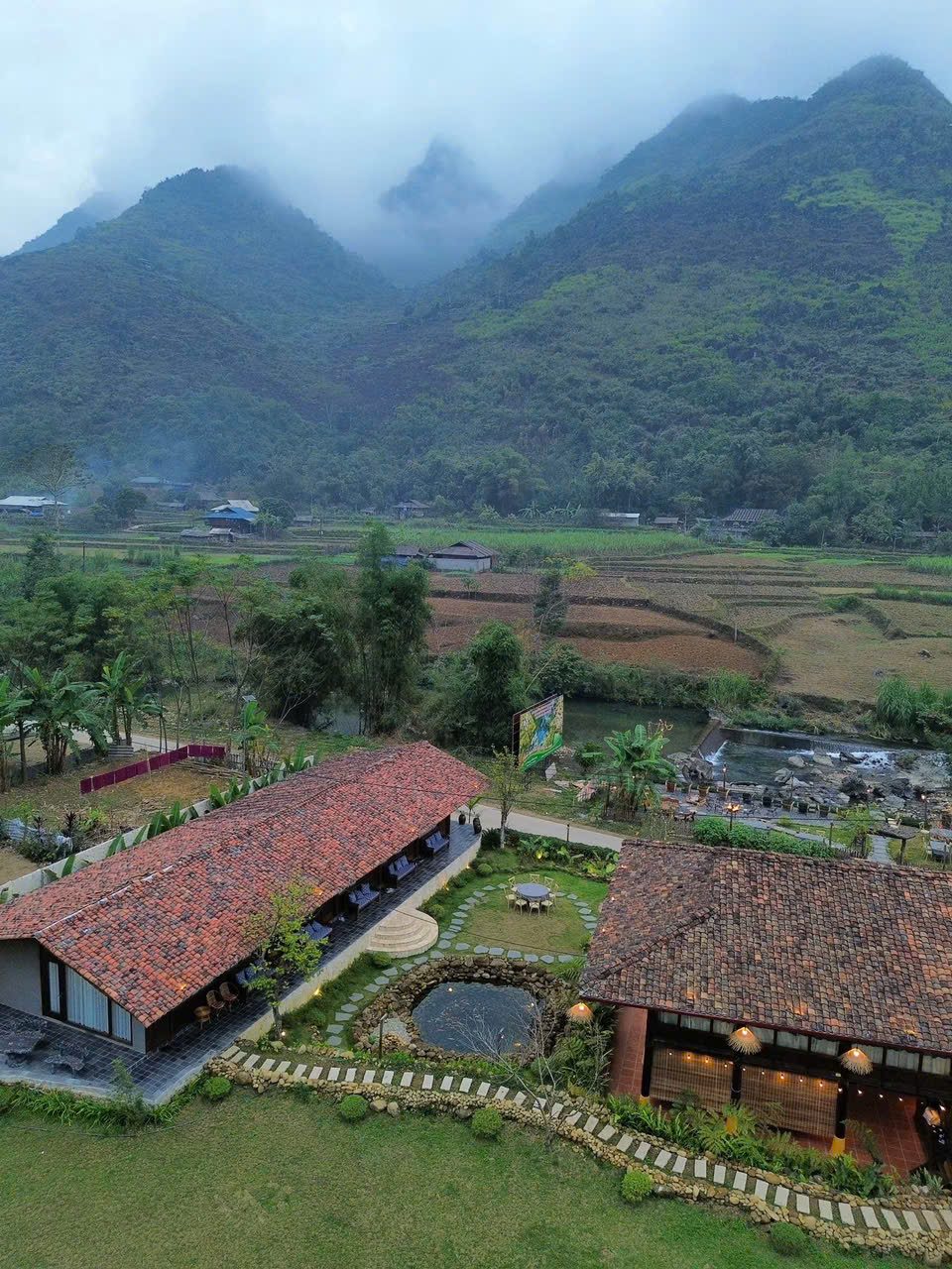 Homestay — dòng suối, nhà mái ngói hoàng hôn